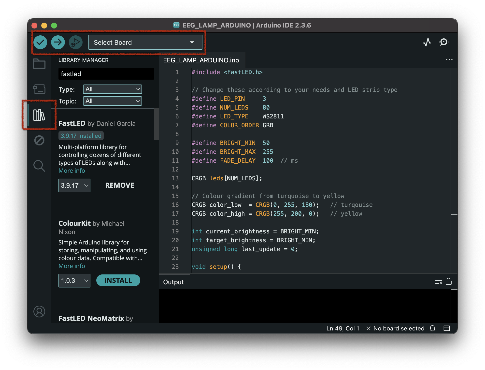 A screenshot of the Arduino IDE with a red rectangle around the relevant top menu items and another red rectangle around the library manager button on the left. The top menu items in the rectangle are the verify button (a checkmark), the upload button (and arrow to the right) and a drop-down menu. The library manager button on the left looks like some books next to each other.